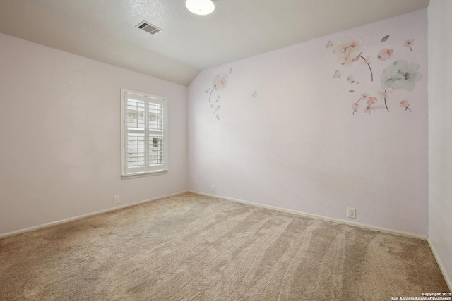 unfurnished room with baseboards, carpet, lofted ceiling, and visible vents