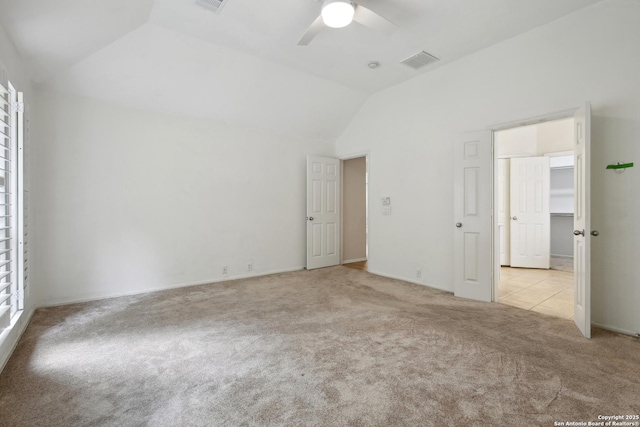 unfurnished bedroom featuring visible vents, a ceiling fan, carpet, and vaulted ceiling