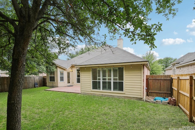 22010 Dolomite, San Antonio, TX 78259 - back of property featuring a lawn, a chimney, a fenced backyard, and a patio area