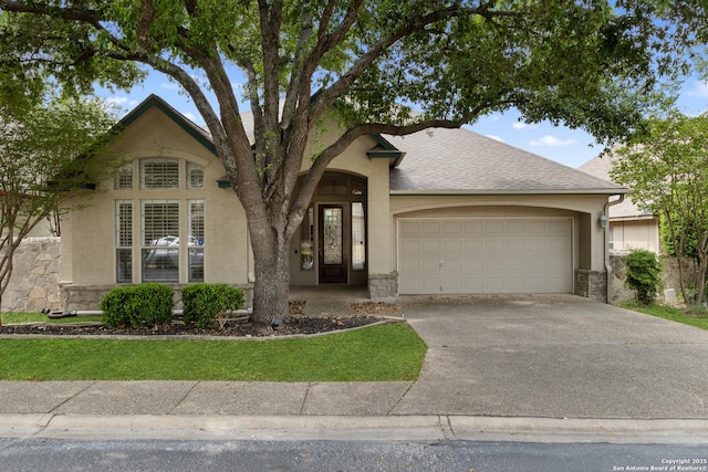 view of front of property with stucco siding, stone siding, concrete driveway, and a garage