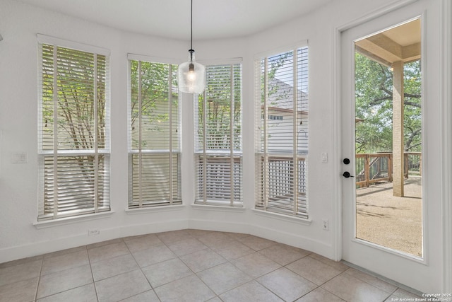 unfurnished dining area featuring baseboards and light tile patterned flooring