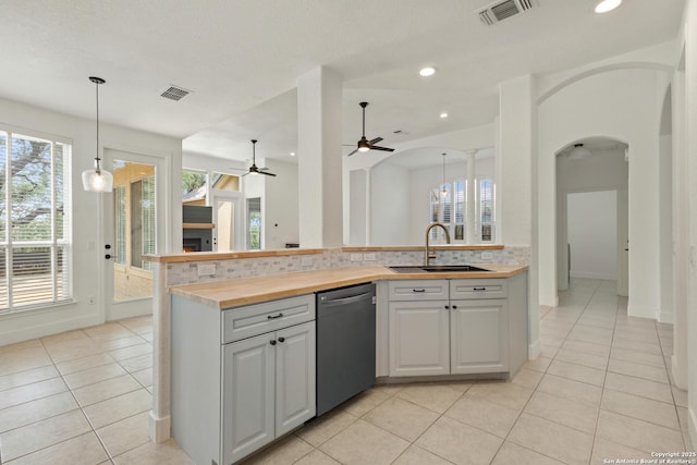 kitchen featuring dishwasher, a ceiling fan, a sink, and visible vents
