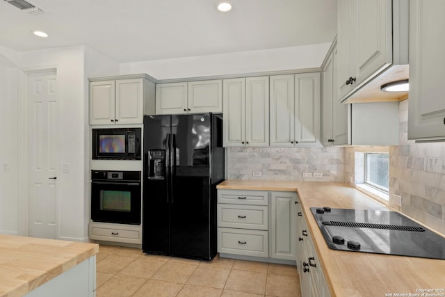 kitchen featuring visible vents, backsplash, black appliances, wooden counters, and light tile patterned floors