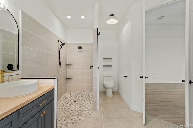 full bath featuring recessed lighting, vanity, tile patterned flooring, and tiled shower