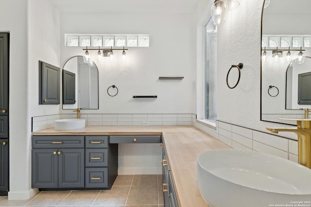 bathroom featuring tile patterned flooring, decorative backsplash, and vanity