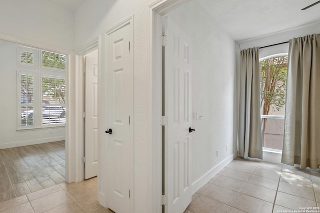 hallway featuring baseboards and light tile patterned floors
