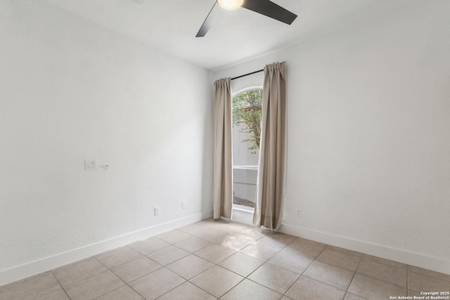 unfurnished room with light tile patterned floors, baseboards, and ceiling fan