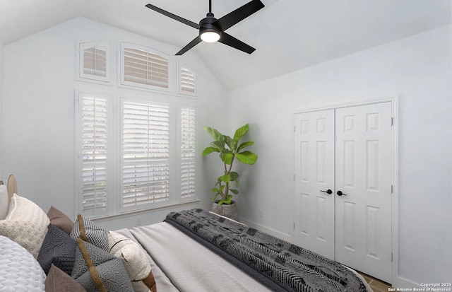 bedroom featuring lofted ceiling, a closet, baseboards, and ceiling fan