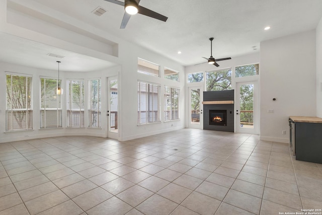 unfurnished living room with recessed lighting, visible vents, light tile patterned floors, a glass covered fireplace, and ceiling fan