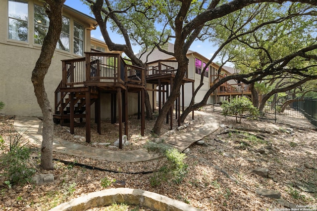 rear view of house featuring stairway, stucco siding, and a deck