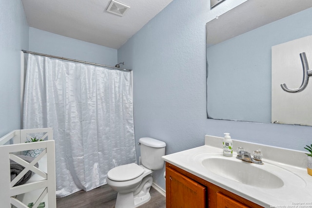 bathroom featuring wood finished floors, visible vents, toilet, vanity, and a shower with shower curtain