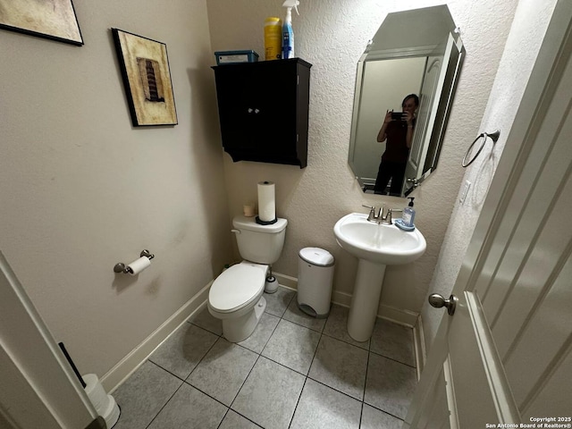 half bath featuring tile patterned floors and toilet