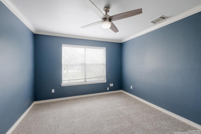 carpeted empty room with visible vents, a ceiling fan, baseboards, and ornamental molding