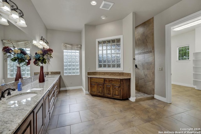 full bathroom featuring baseboards, visible vents, vanity, and a walk in shower