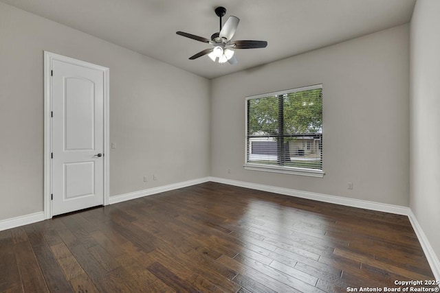 spare room with a ceiling fan, baseboards, and dark wood-type flooring