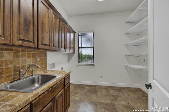 clothes washing area featuring a sink, baseboards, washer hookup, cabinet space, and electric dryer hookup