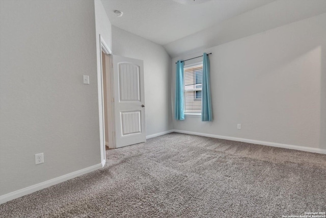 unfurnished room with carpet floors, vaulted ceiling, and baseboards
