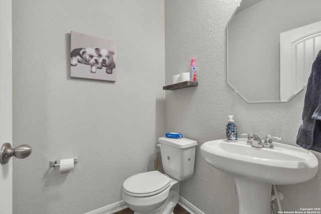 half bath featuring toilet and a sink
