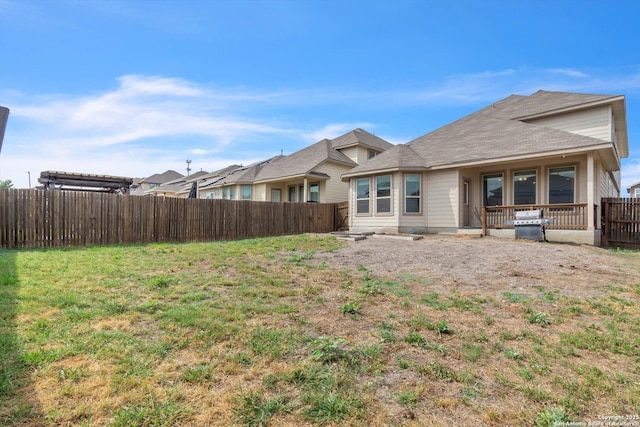 rear view of house with a fenced backyard