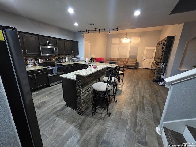 12031 Mill Love, San Antonio, TX 78254 - kitchen featuring stainless steel appliances, rail lighting, a breakfast bar, a peninsula, and wood finished floors