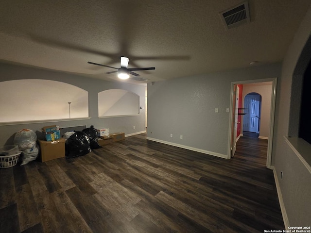 12031 Mill Love, San Antonio, TX 78254 - unfurnished living room featuring a ceiling fan, dark wood-style flooring, arched walkways, a textured ceiling, and baseboards