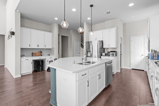 kitchen featuring dark wood-type flooring, visible vents, stainless steel appliances, and a sink