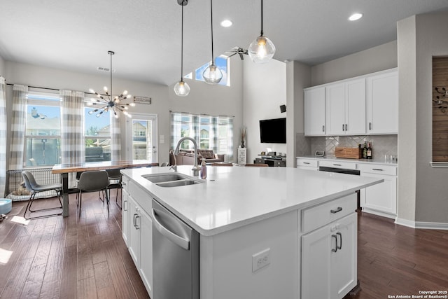 kitchen featuring plenty of natural light, dishwasher, a sink, and an inviting chandelier