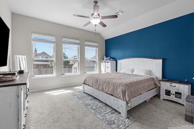 carpeted bedroom with vaulted ceiling, a ceiling fan, visible vents, and baseboards