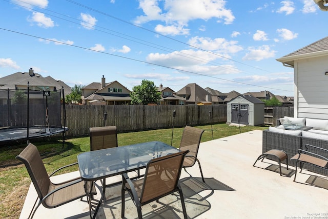 view of patio / terrace featuring an outdoor living space, a trampoline, a fenced backyard, a residential view, and a storage unit