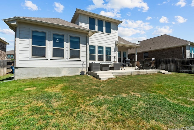 rear view of property with a yard, a patio, and a fenced backyard