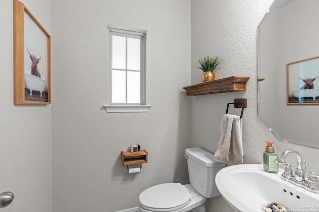half bathroom with toilet and a sink