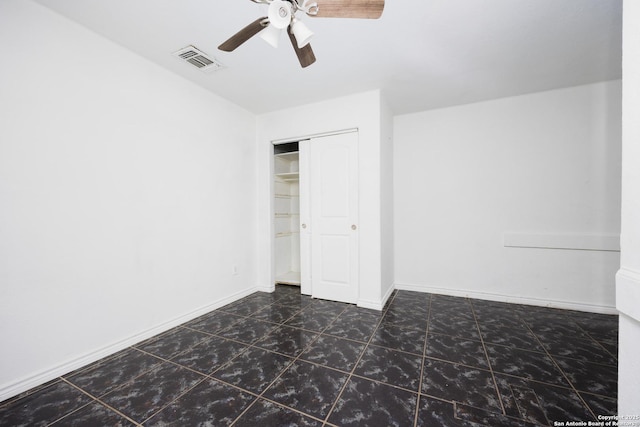 unfurnished bedroom featuring tile patterned floors, visible vents, a ceiling fan, a closet, and baseboards