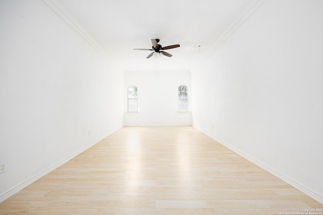 empty room featuring light wood finished floors, a ceiling fan, baseboards, and ornamental molding