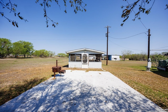 view of front of home with a sunroom and a front lawn