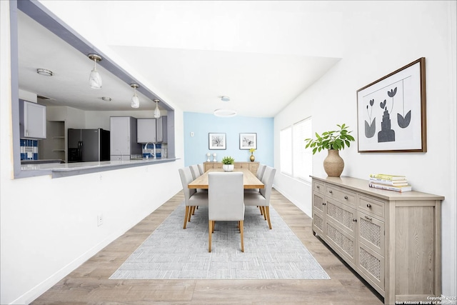 dining area with baseboards and light wood-style floors