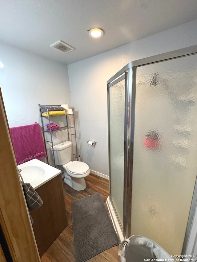full bath featuring visible vents, a stall shower, wood finished floors, vanity, and toilet