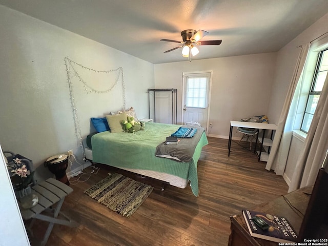 bedroom featuring baseboards, ceiling fan, and wood finished floors
