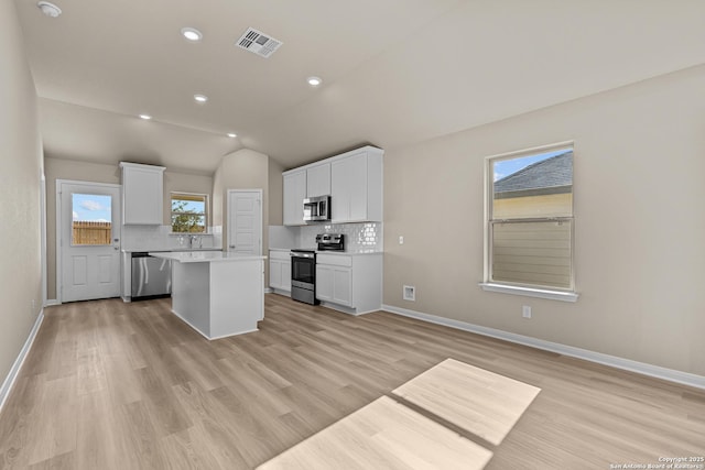 4265 Carlotta Dr, New Braunfels, TX 78130 - kitchen with stainless steel appliances, tasteful backsplash, a center island, white cabinetry, and vaulted ceiling