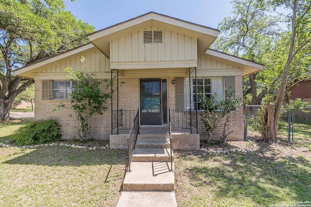 324 Craddock, San Marcos, TX 78666 - bungalow-style house with board and batten siding, fence, brick siding, and a front yard