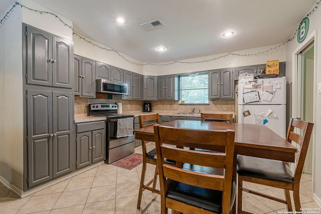 324 Craddock, San Marcos, TX 78666 - kitchen with gray cabinetry, a sink, appliances with stainless steel finishes, and tasteful backsplash