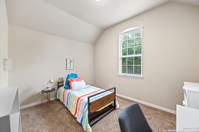 bedroom with baseboards, vaulted ceiling, and carpet