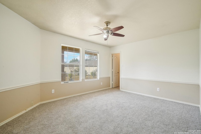 spare room featuring a ceiling fan, carpet flooring, and baseboards