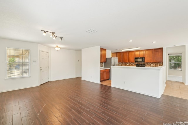 unfurnished living room featuring wood finished floors, plenty of natural light, recessed lighting, and baseboards