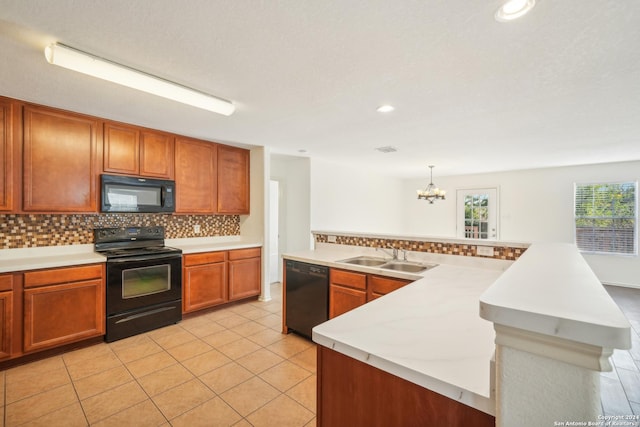 kitchen featuring a sink, a chandelier, black appliances, backsplash, and light countertops