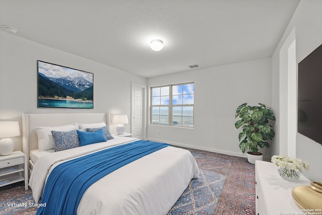 bedroom with baseboards and visible vents