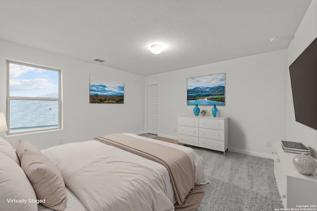 bedroom featuring visible vents, light carpet, and baseboards