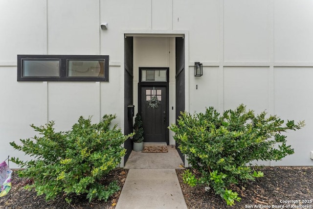 doorway to property featuring stucco siding