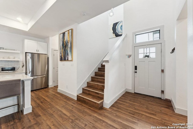 entryway with baseboards, dark wood-type flooring, and stairway