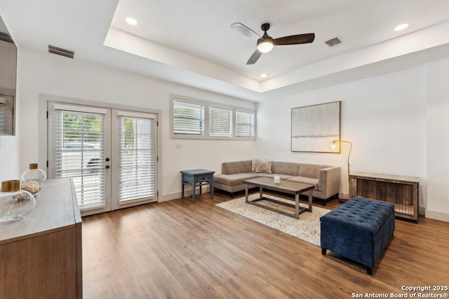living area with wood finished floors, visible vents, and ceiling fan