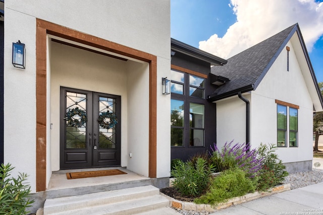 doorway to property featuring french doors, a shingled roof, and stucco siding